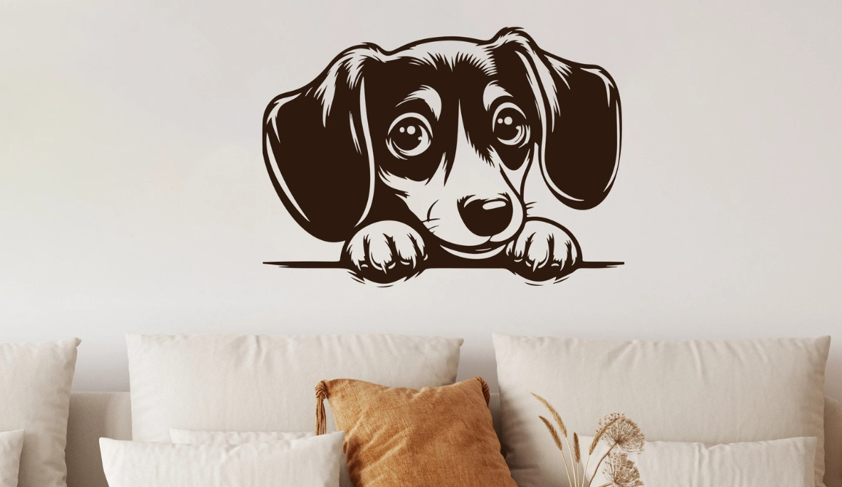 Schwarzes Wandtattoo mit Hundekopf über einem hellen Sofa an einer hellen Wand.