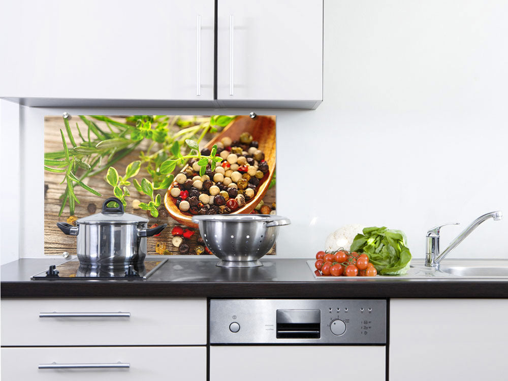 Küchenrückwand mit bunten Pfefferkörnern und Kräutern.