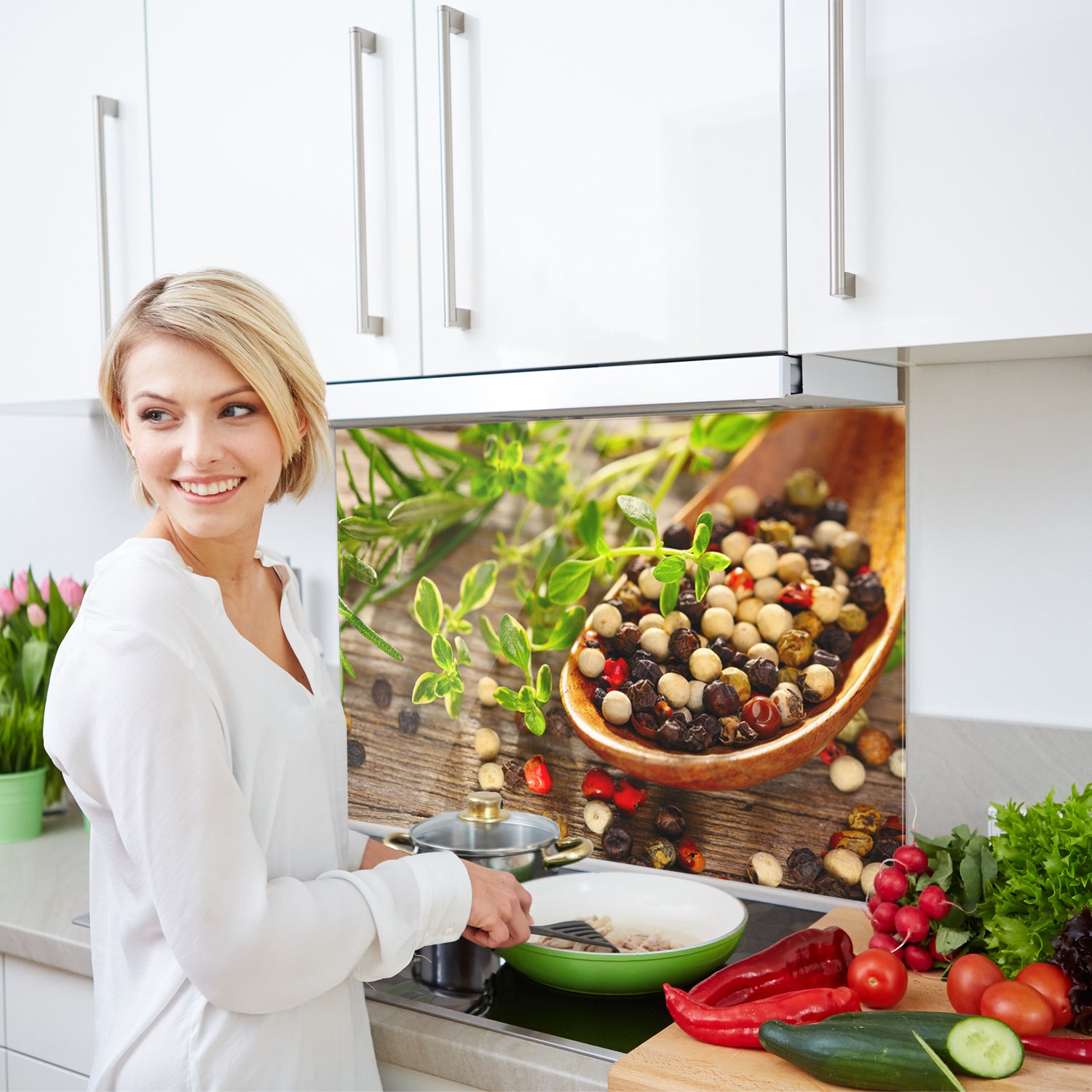 Köchin mit bunten Pfefferkörnern und frischen Kräutern.