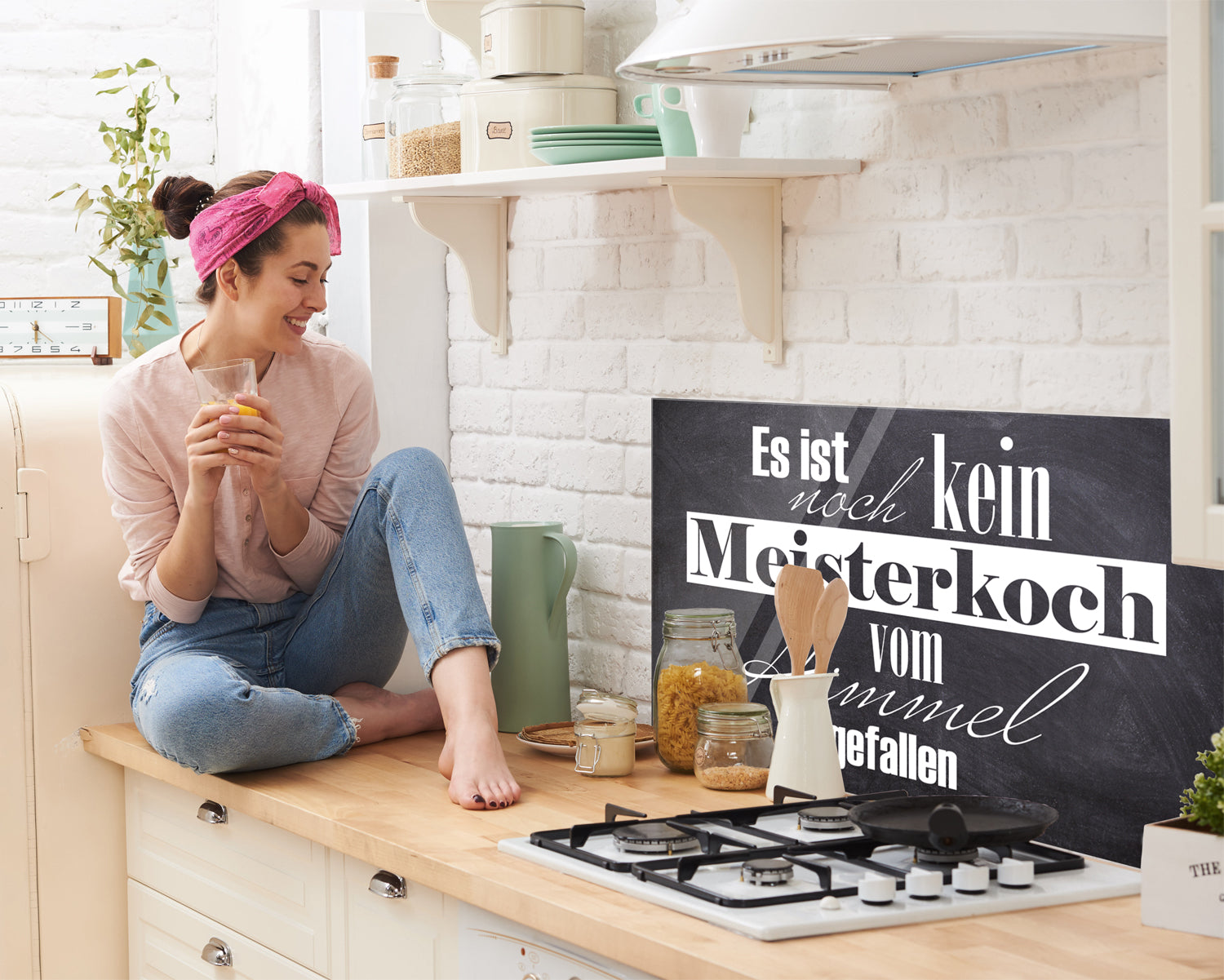 Schwarzes Schild mit weißem Text, Küchenumgebung, fröhliche Frau.