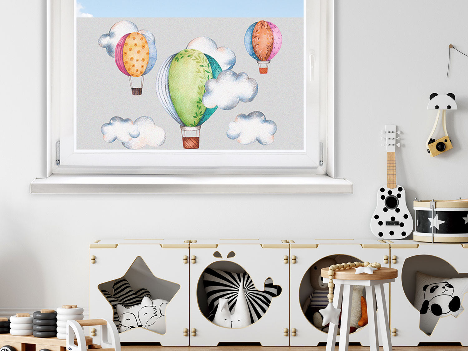 Bunte Luftballons und Wolken vor einem hellblauen Himmel.