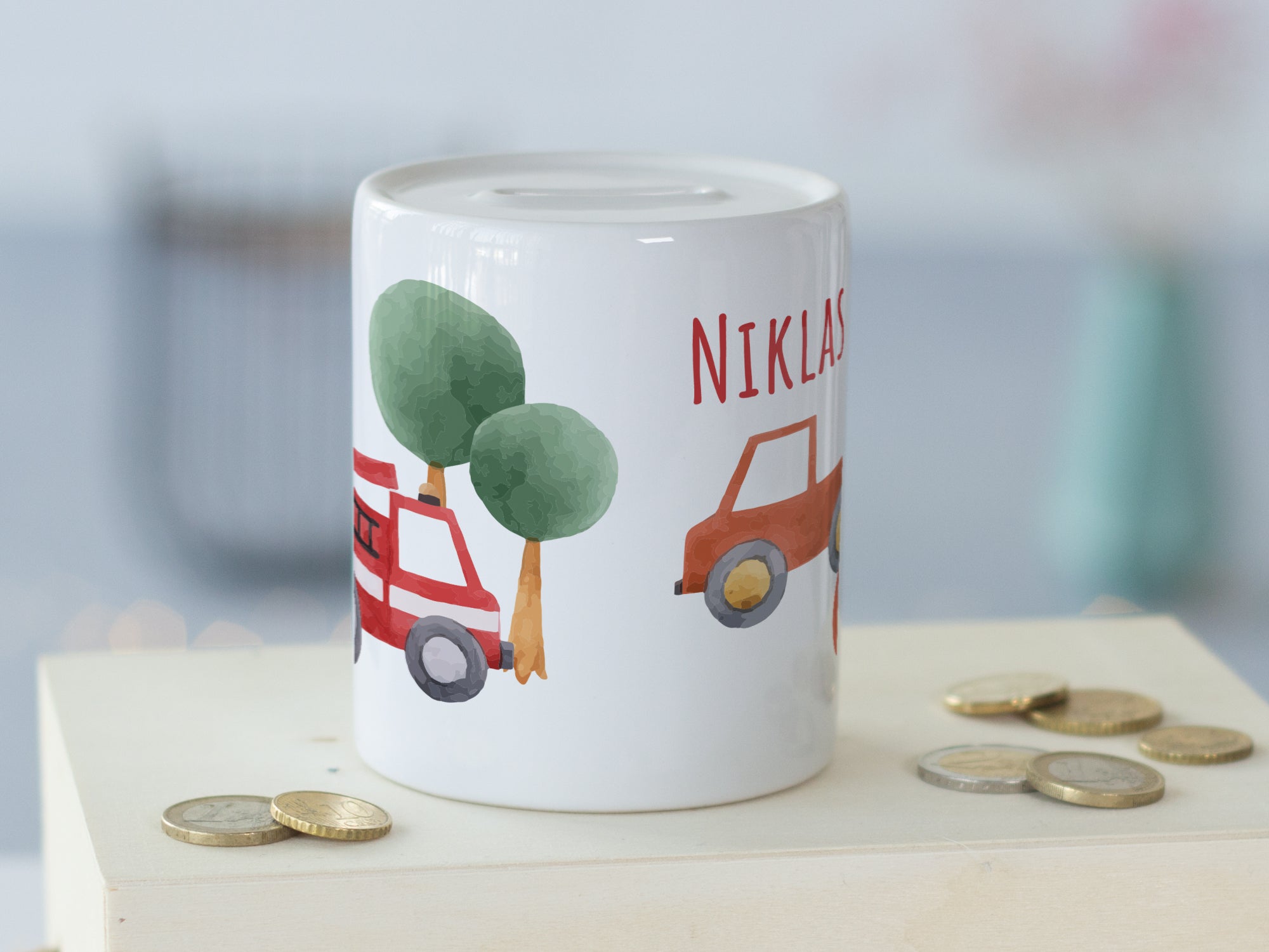 Personalisierte Spardose mit roten Autos und Bäumen.