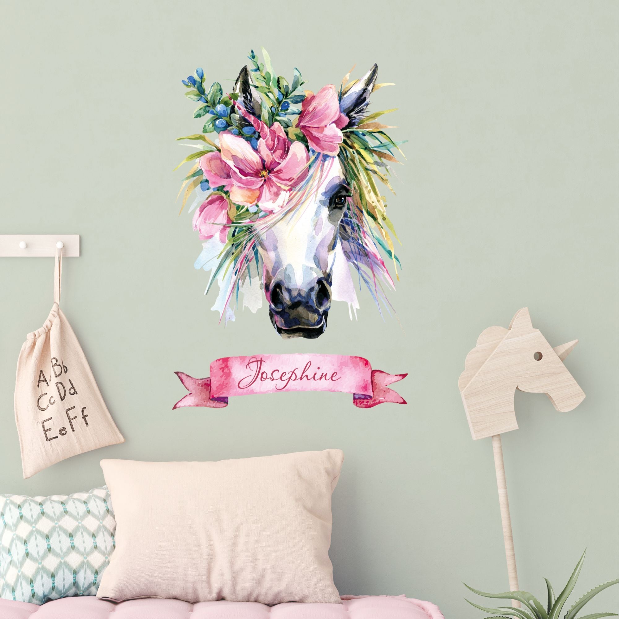 Weißes Pferd mit Blumenkranz und rosa Banner.