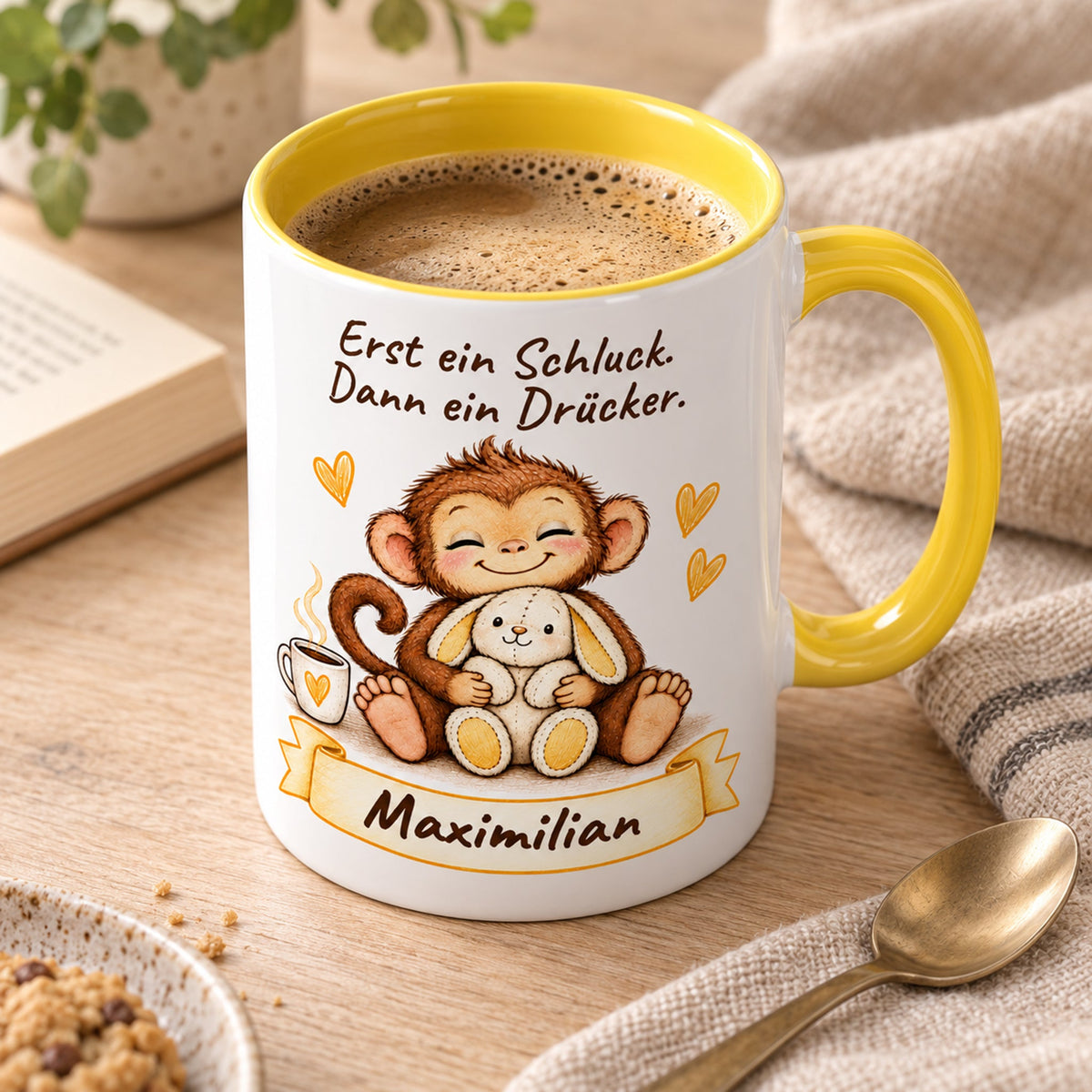 Schrägansicht: gelbe personalisierte Tasse mit Baby-Affe, Motiv Schluck und Drücker, Beispielname Maximilian