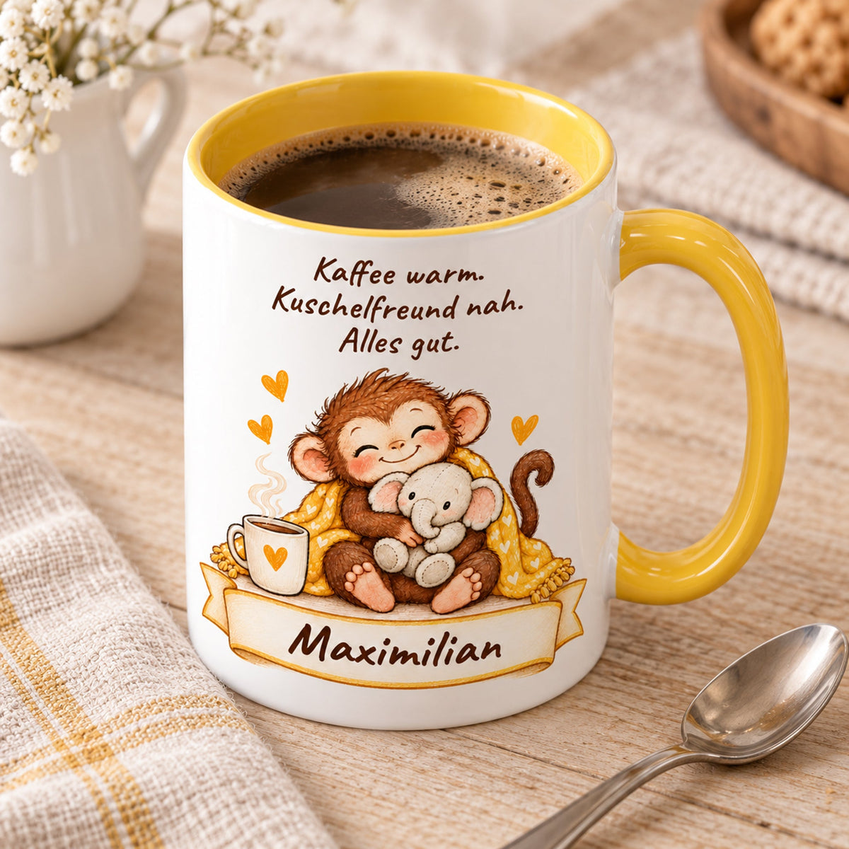 Schrägansicht: gelbe personalisierte Tasse mit Baby-Affe, Motiv Kuschelfreund Elefant, Beispielname Maximilian