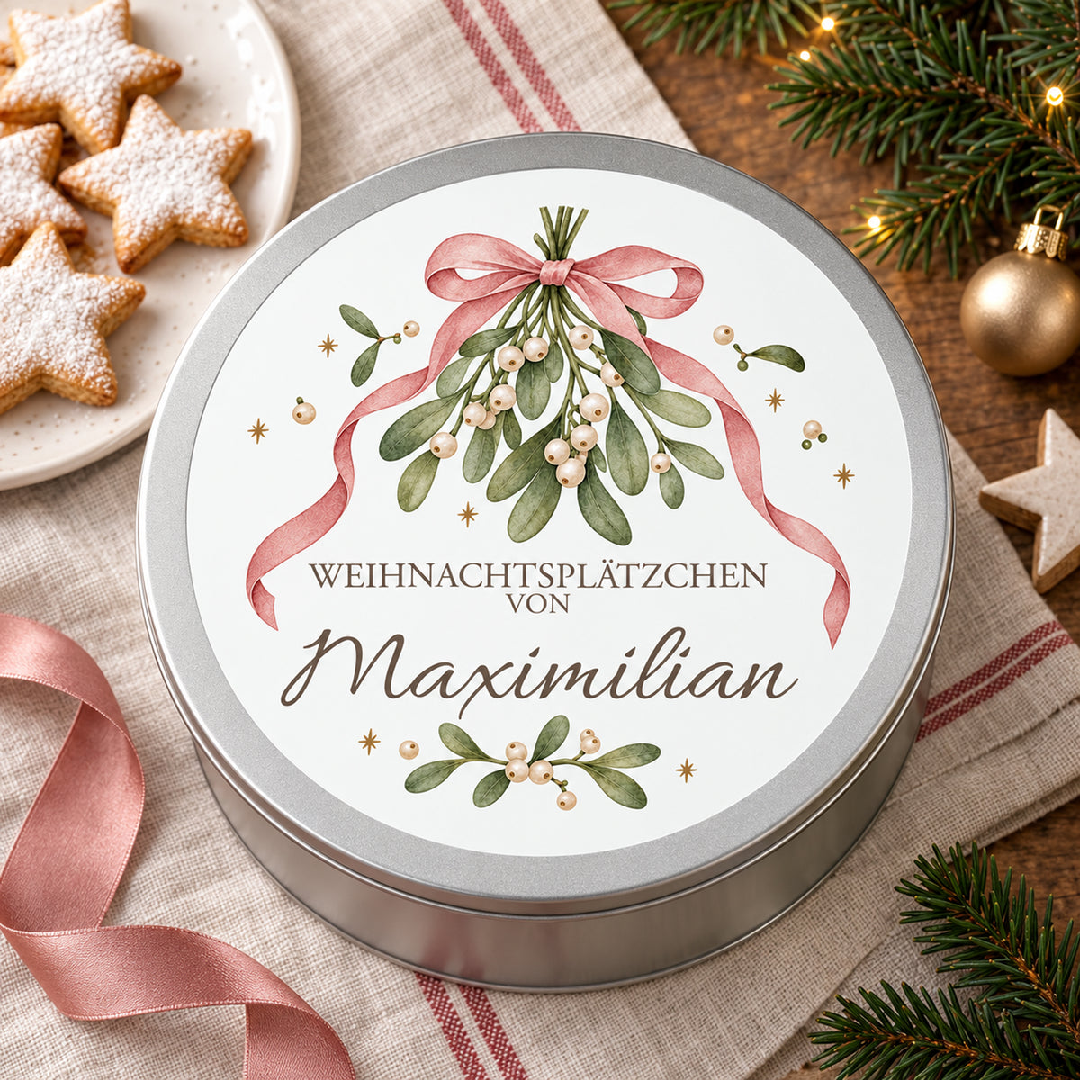 Keksdose mit Mistel & Schleife-Motiv als Weihnachtsgeschenk neben Plätzchen und festlicher Dekoration