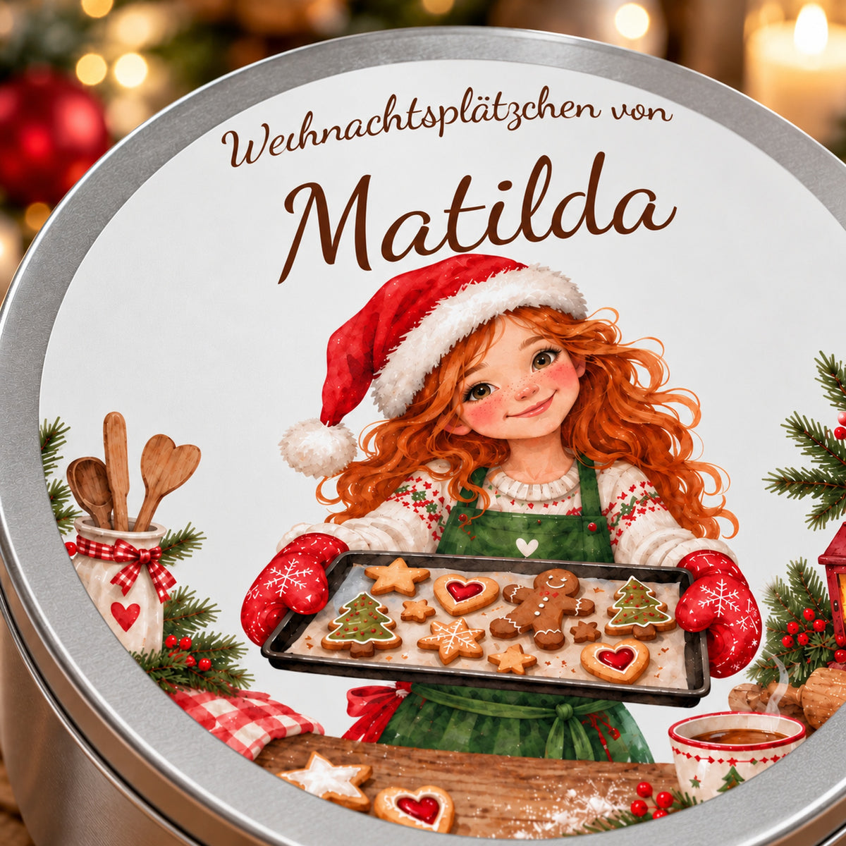 Nahaufnahme des Namens und des Aquarellmotivs einer Weihnachtsbäckerin beim Präsentieren eines Plätzchenblechs auf dem Dosendeckel.