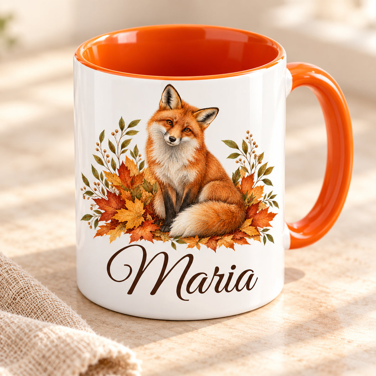 Tasse mit Fuchs und Herbstblättern und Namensdruck in schräger Ansicht mit orangefarbenem Innenbereich.