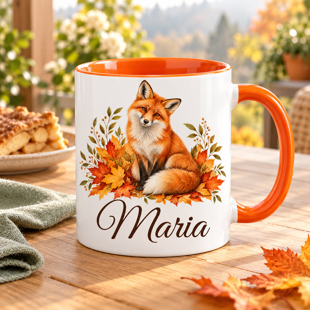 Personalisierte Fuchstasse mit orangefarbenem Henkel auf einer herbstlichen Frühstücksterrasse.