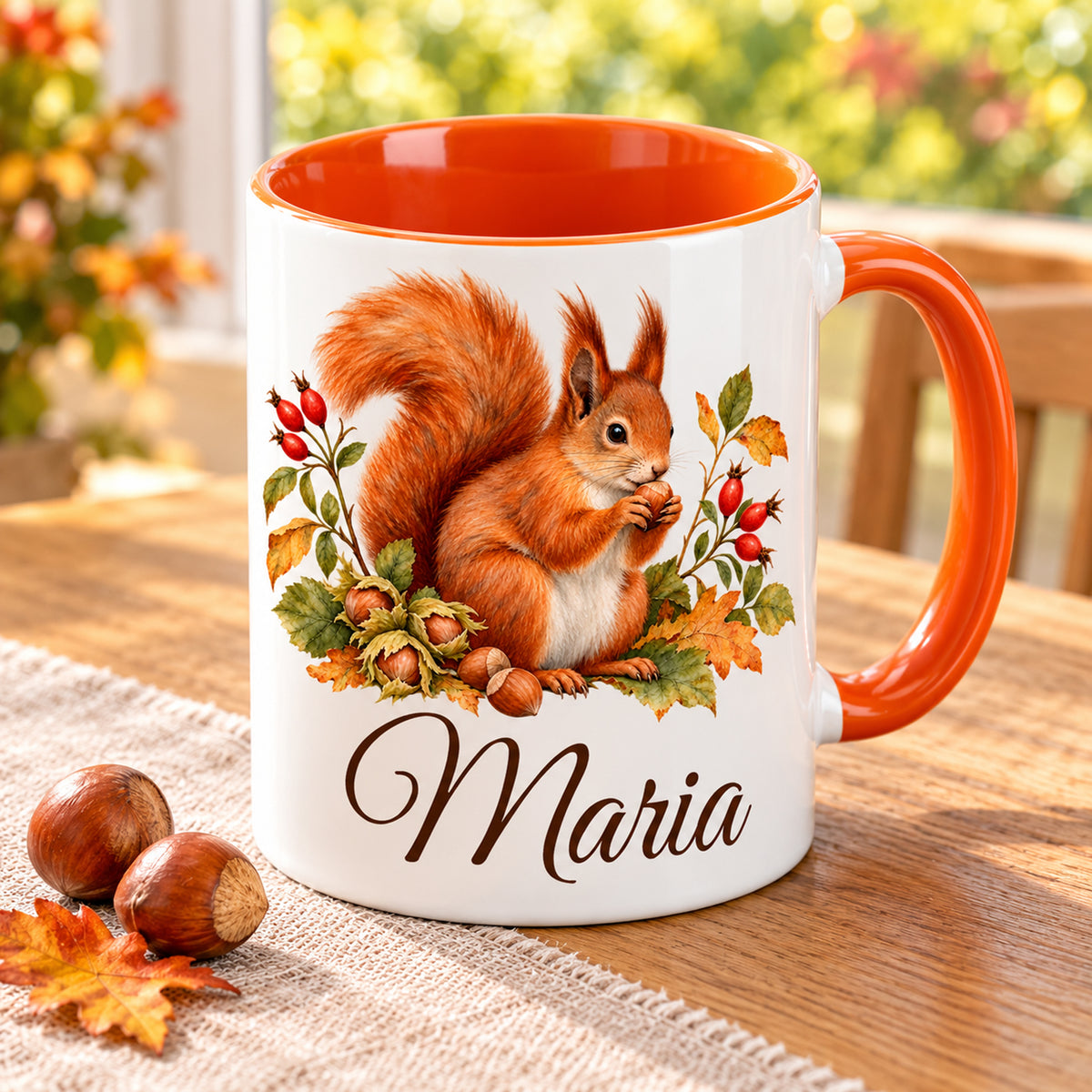 Schrägansicht einer Tasse mit Eichhörnchen, Herbstlaub, Wunschname und orangefarbener Innenseite.