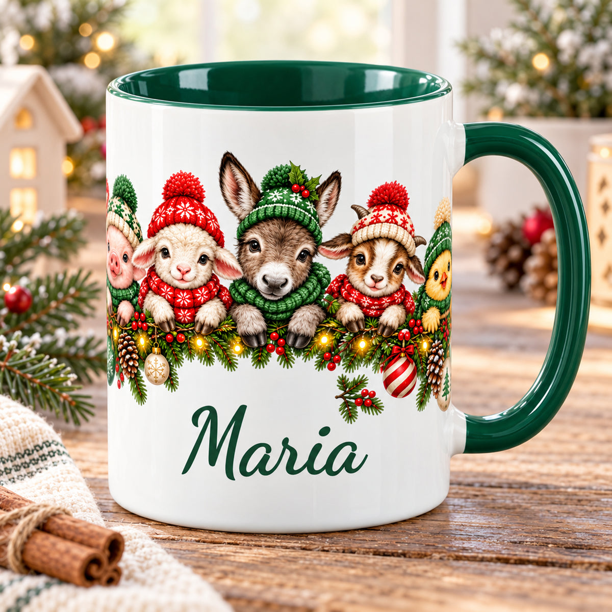 Weiße Weihnachtstasse mit grünem Henkel, grünem Inneren, Bauernhoftieren in Wintermützen und einem Wunschnamen auf einem Holztisch.