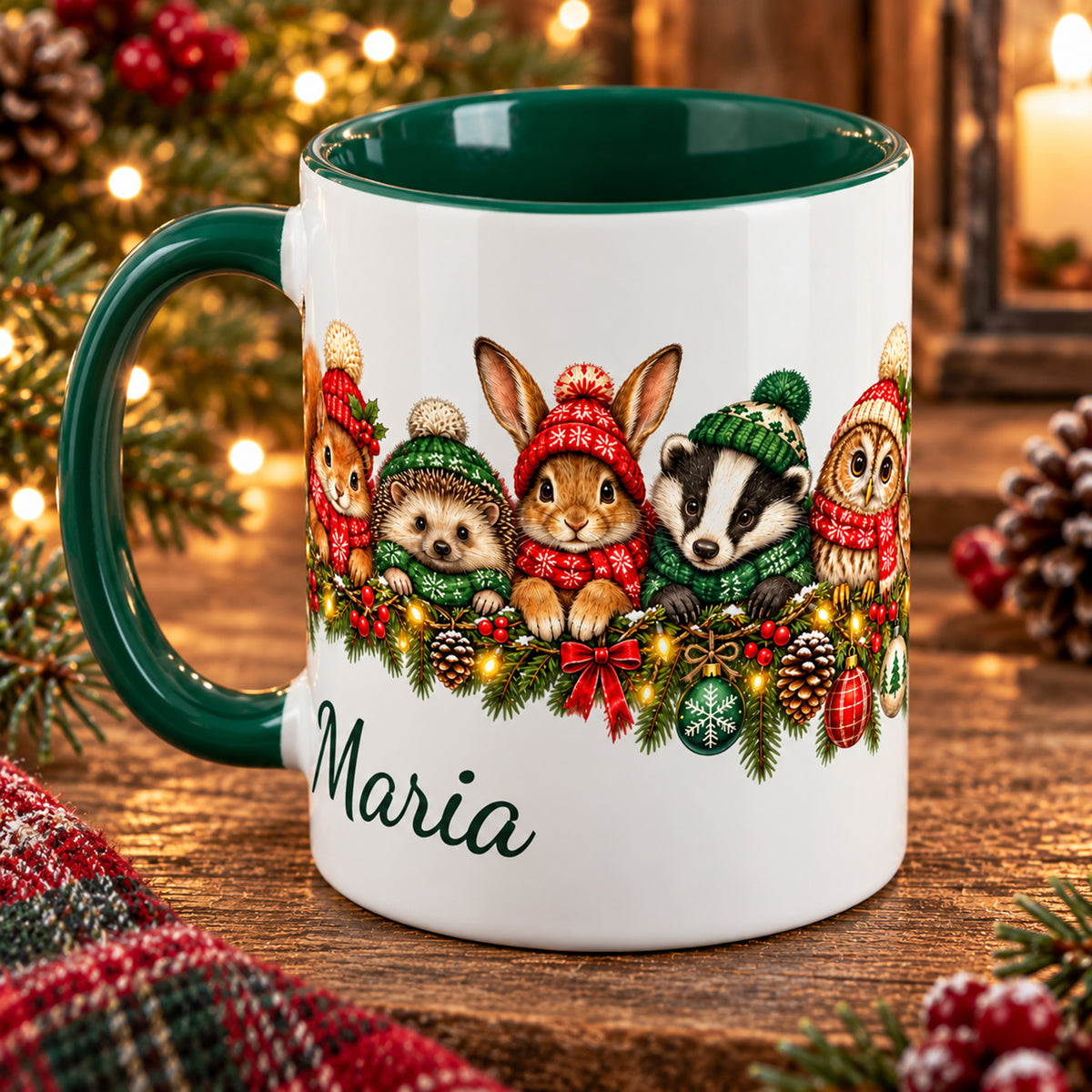 Grün-weiße Weihnachtstasse mit Waldtieren und einem Wunschnamen, Henkel links und seitlich fortgeführtem Tiermotiv vor warmem Holzhintergrund.