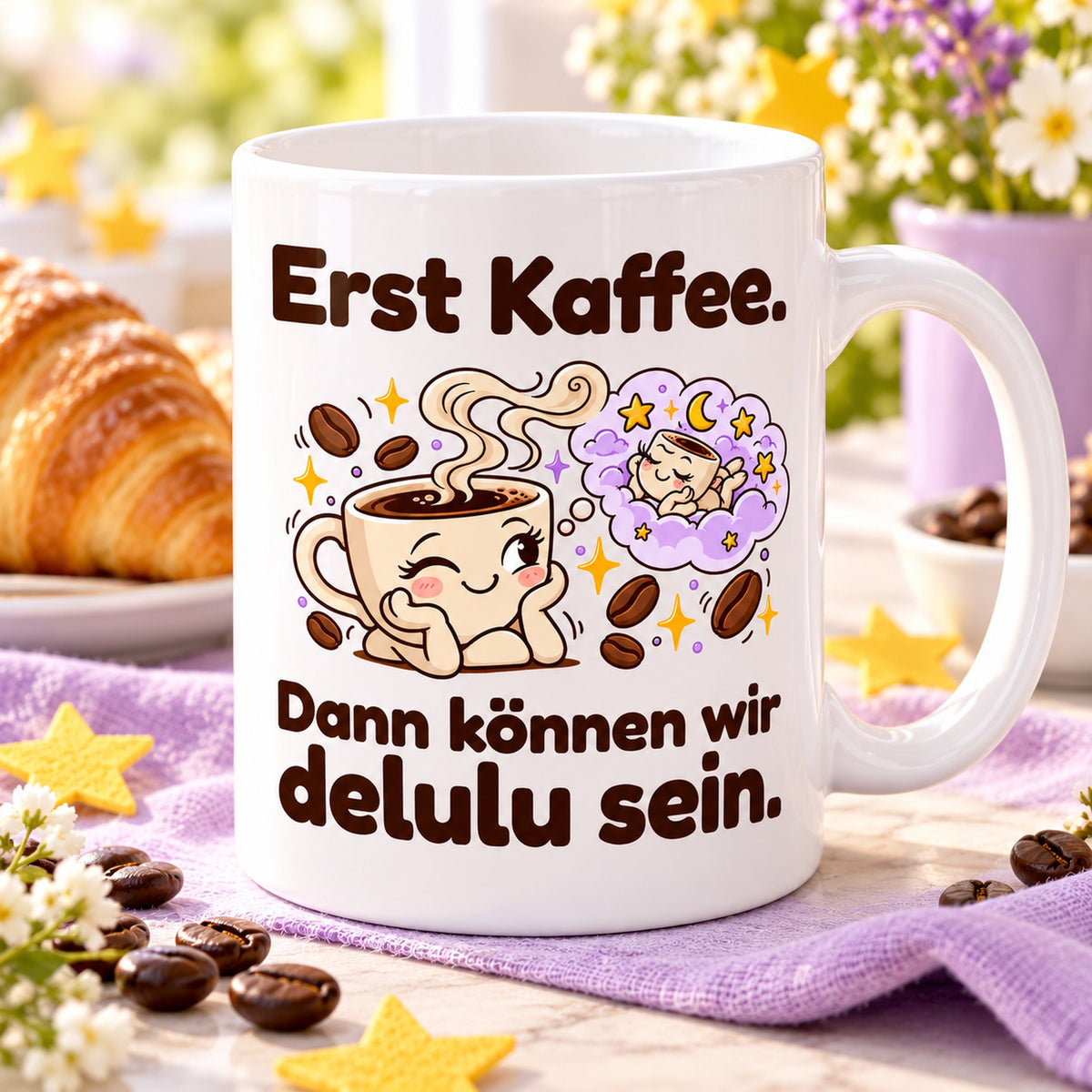 Tasse mit dem Spruch „Erst Kaffee. Dann können wir delulu sein.“ bei einer Kaffeepause auf hellem Tisch mit lila Tuch und Sternen.