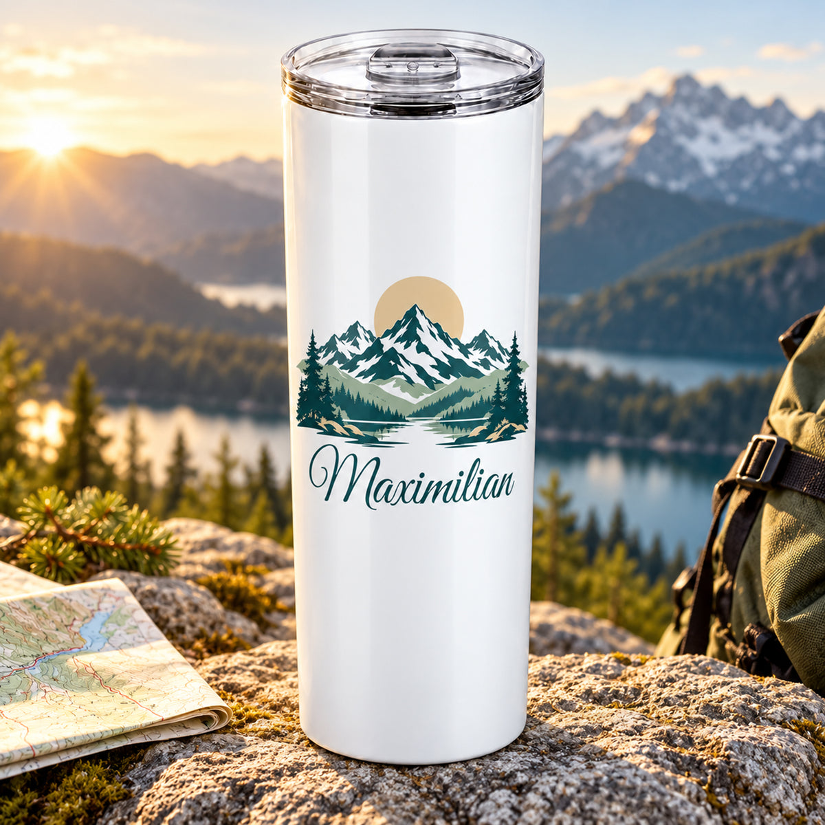 Thermobecher mit Berggipfeln und Sonne und Wunschname auf hellem Fels im Morgenlicht.