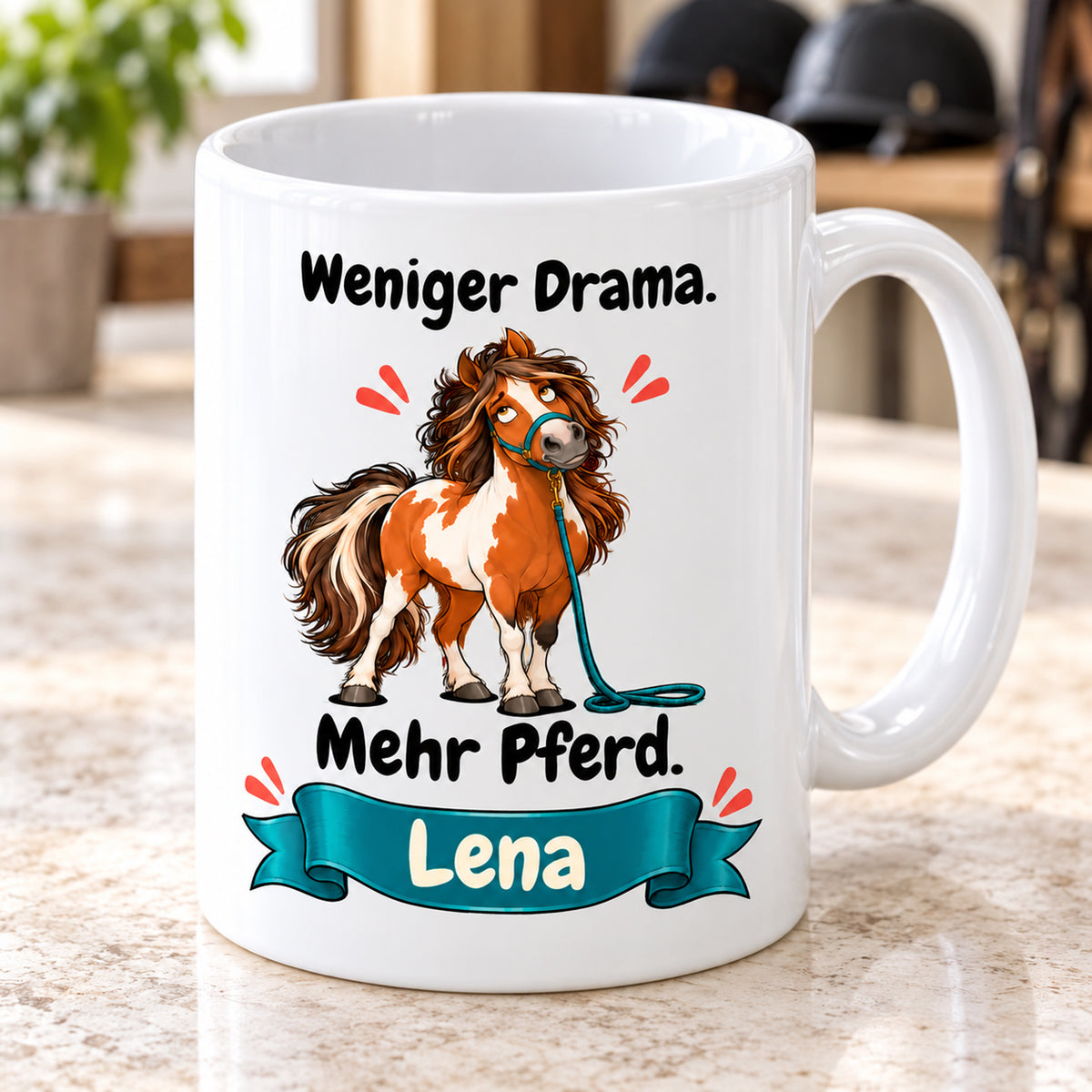 Weiße Pferdetasse mit Namen, Schecken mit petrolfarbenem Strick und Spruch „Weniger Drama. Mehr Pferd.“, schräg von vorn.