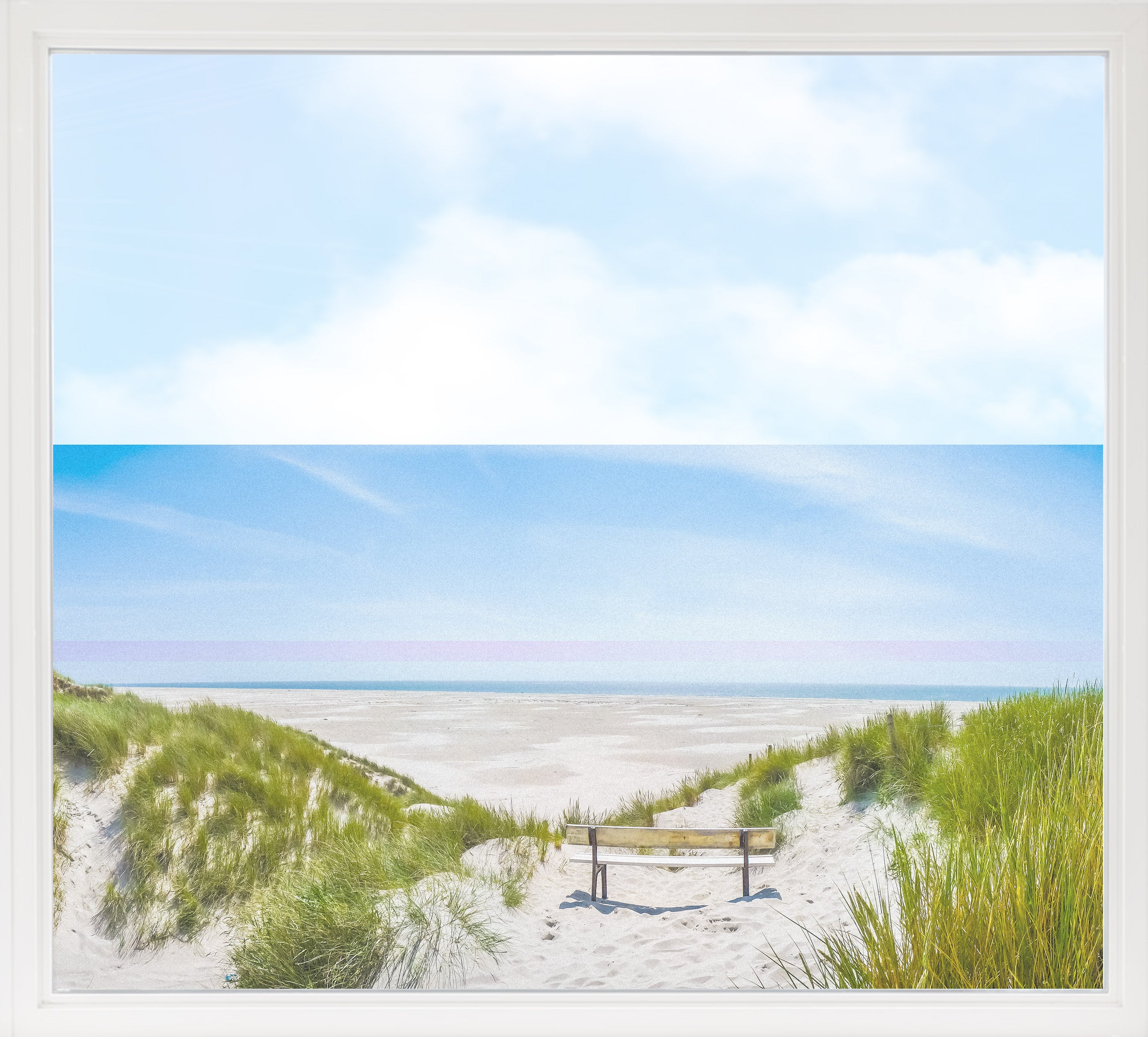 Strandlandschaft mit Bank, blauer Himmel und grünem Gras.