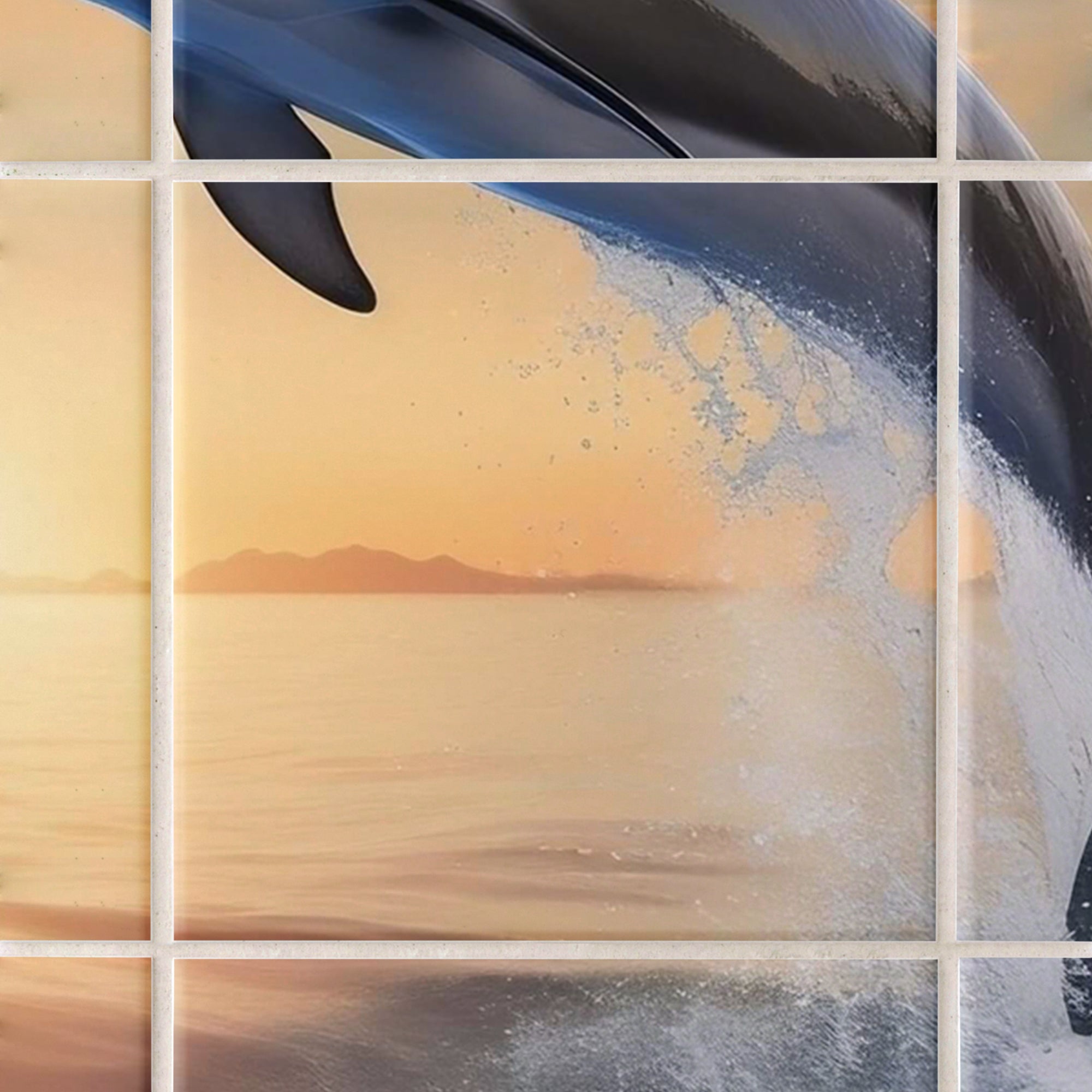 Springender Delfin vor orangefarbenem Sonnenuntergang.