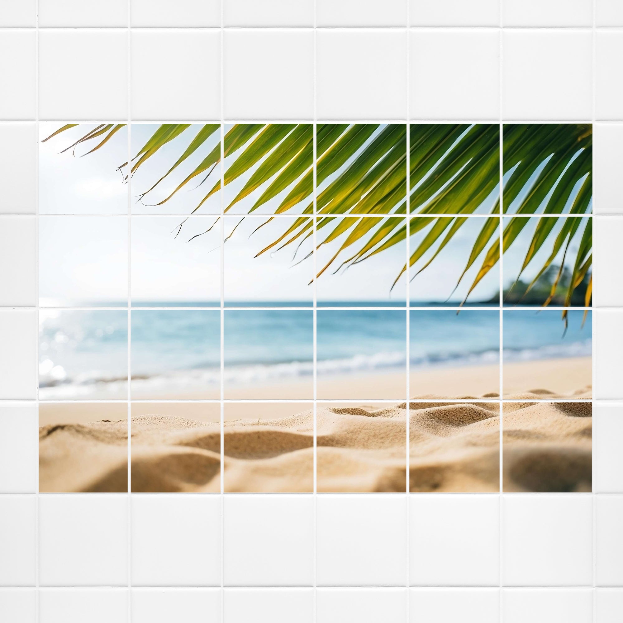 Grünes Palmblatt über Sandstrand und Meer.