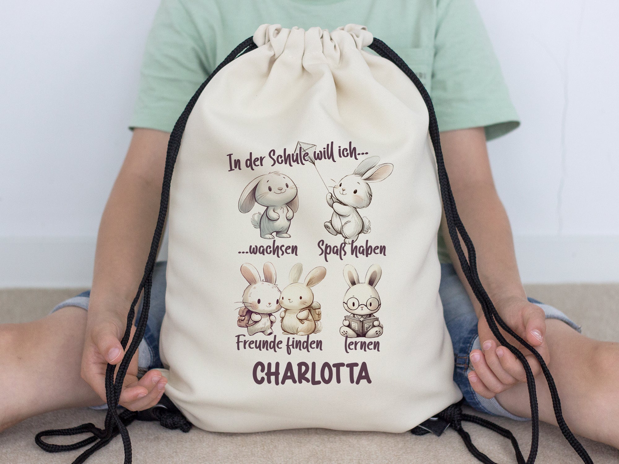Beige Turnbeutel mit Hasenmotiven und personalisiertem Namen.