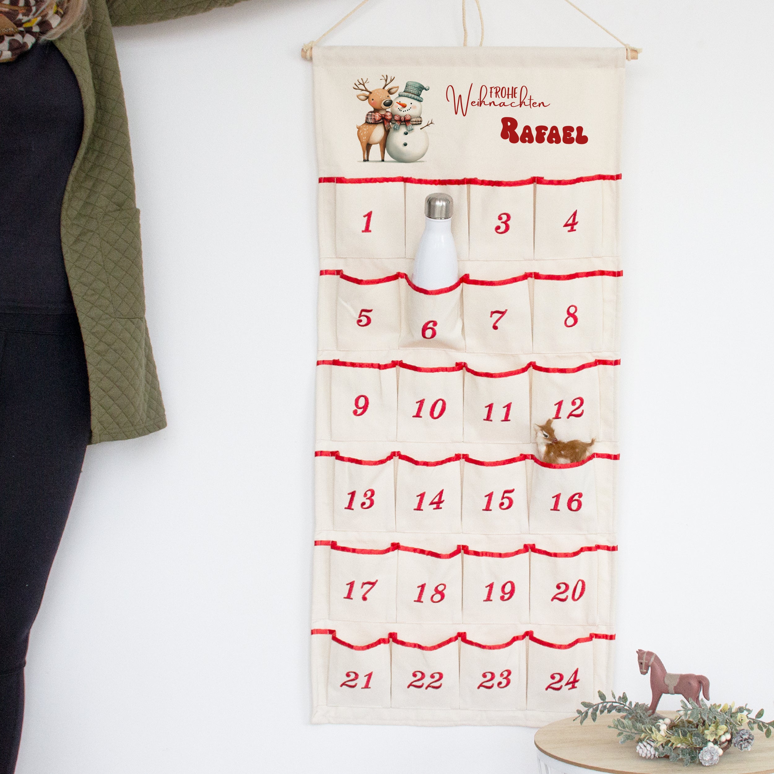 Adventskalender aus Stoff, cremefarben mit roten Akzenten.