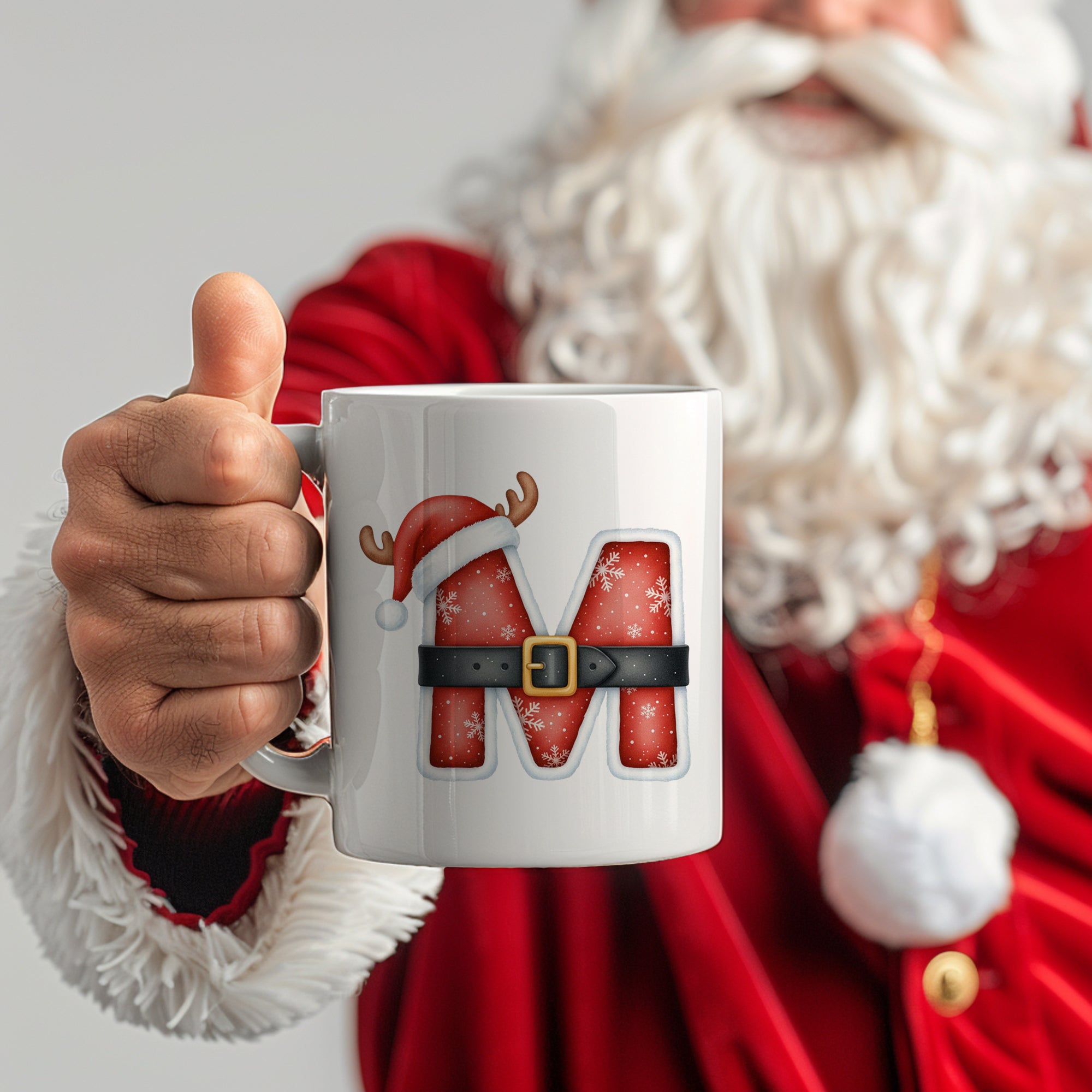 Weißer Becher mit rotem "M" und Weihnachtsmotiv.