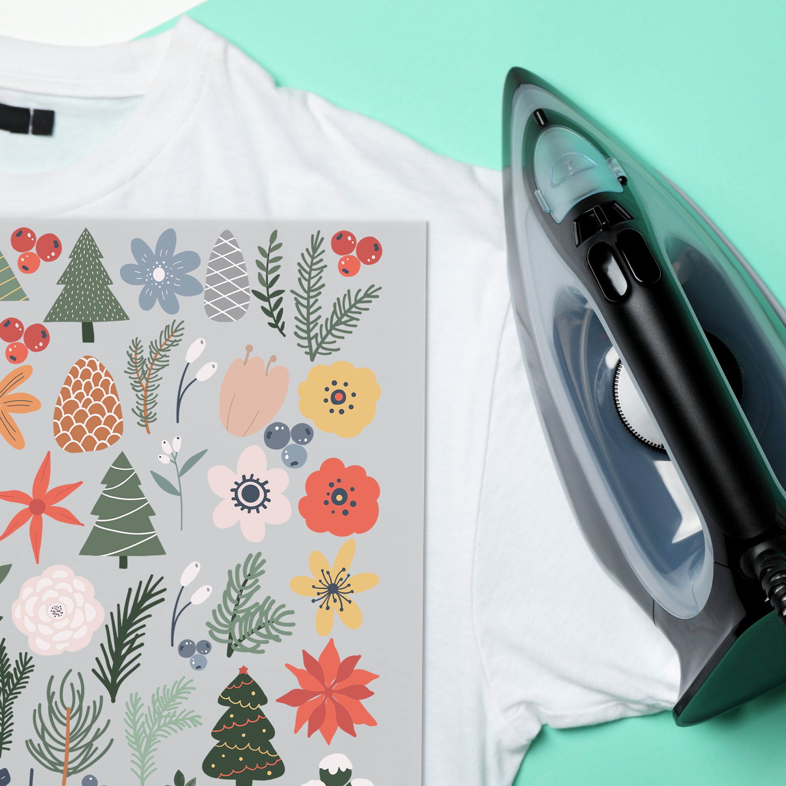 Winterblumen-Bügelbilder auf weißem T-Shirt neben einem Bügeleisen