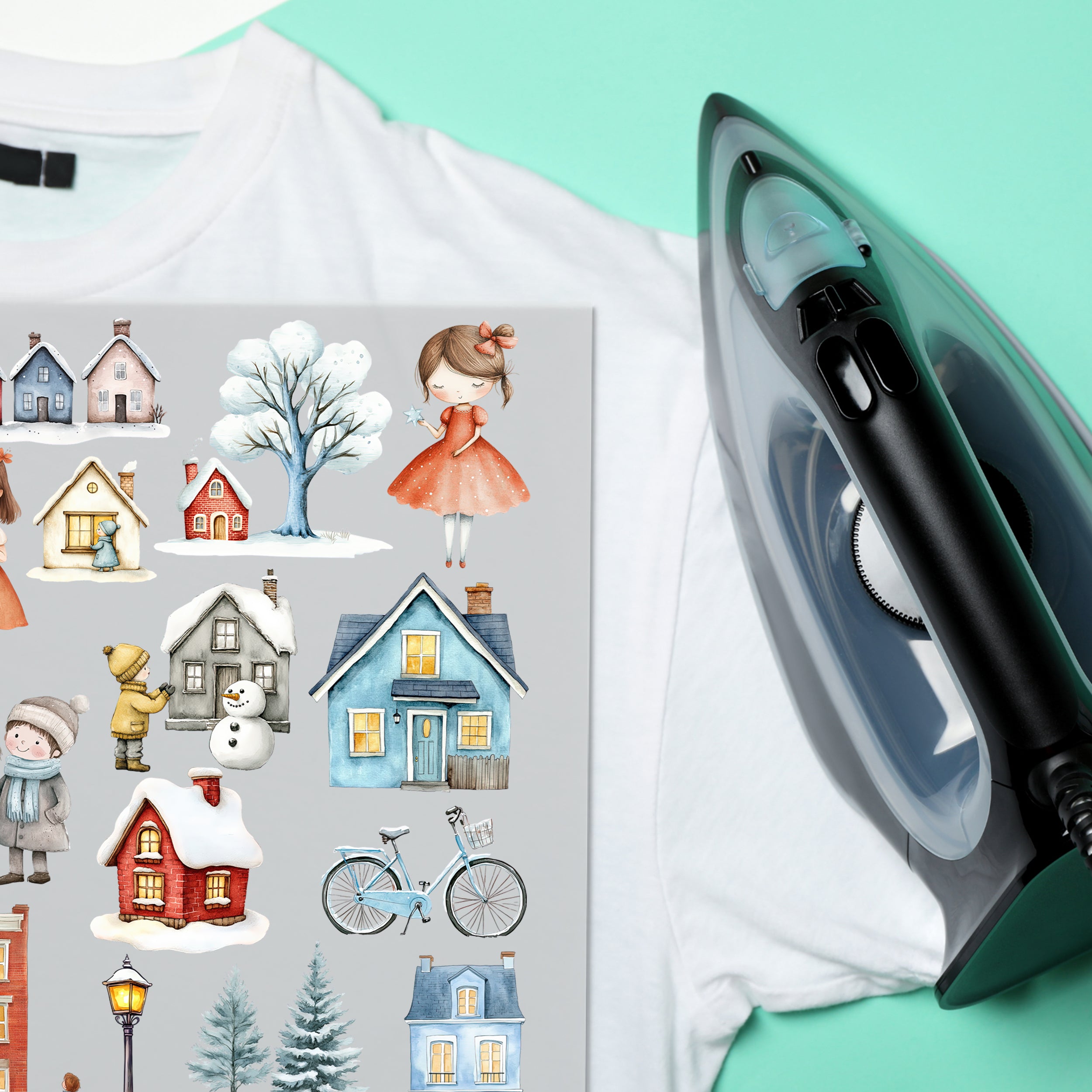 Winterdorf-Bügelbilder auf einem weißen T-Shirt neben einem Bügeleisen