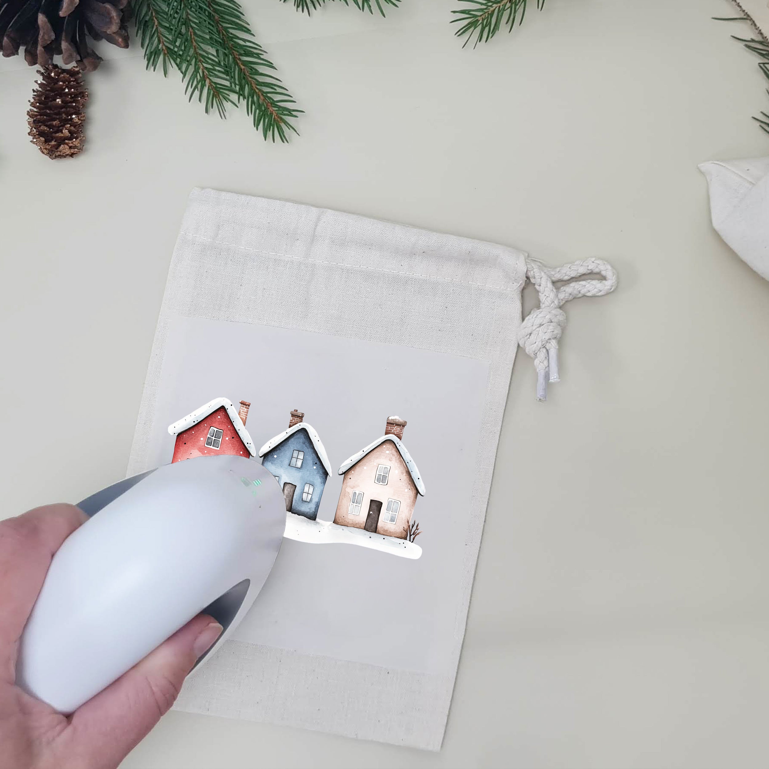 Winterliches Häuser-Bügelbild wird mit einer Mini-Transferpresse auf einen weißen Stoffbeutel aufgebracht