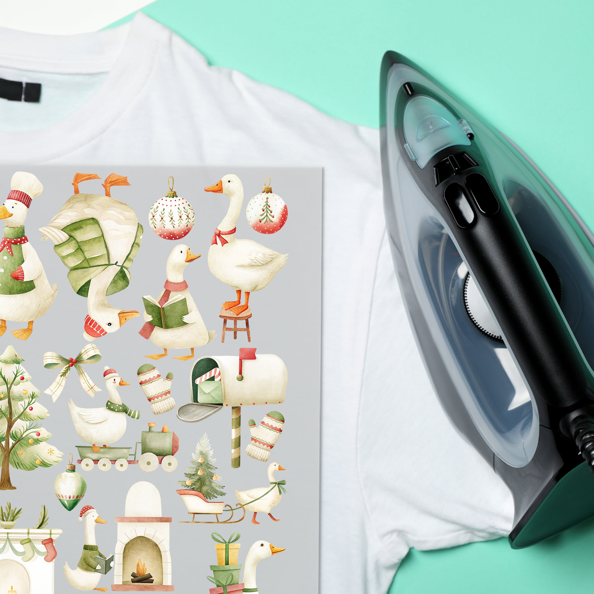 Weihnachtliche Gänse-Bügelbilder auf weißem T-Shirt neben einem Bügeleisen