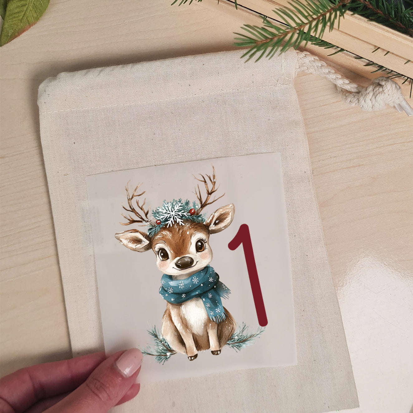 Weihnachtsrentier-Bügelbild mit Zahl 1 auf einem naturfarbenen Adventskalenderbeutel