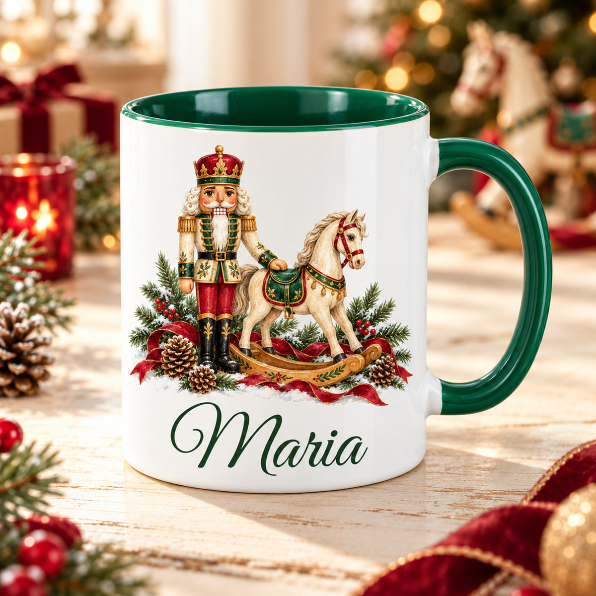 Weiße Keramiktasse mit grünem Henkel und grüner Innenseite, Motiv Nussknacker mit Schaukelpferd und Wunschname vor weihnachtlicher Dekoration.