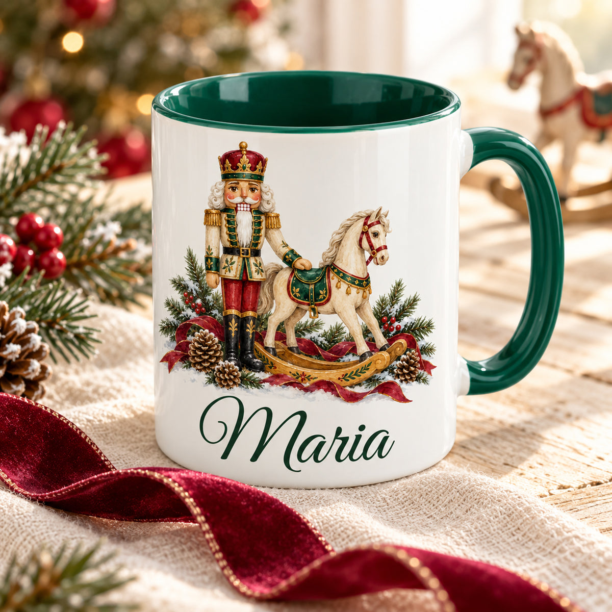 Weiße Keramiktasse mit grünem Henkel und grüner Innenseite, Motiv Nussknacker mit Schaukelpferd und Wunschname in schräger Ansicht auf Leinen mit Geschenkband.