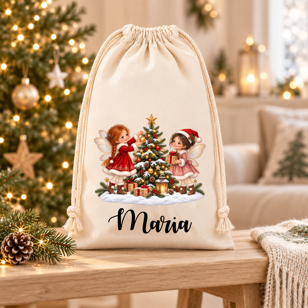 Nikolaussack mit zwei Feen an einem verschneiten Weihnachtsbaum und dem Namen Maria auf einer hellen Holzablage in weihnachtlicher Wohnumgebung.