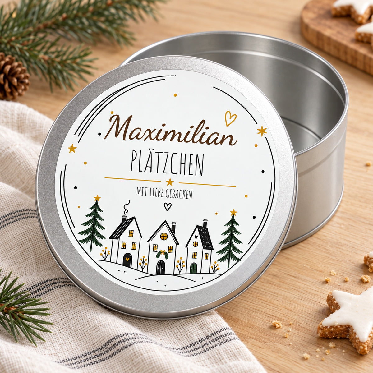 Offene silberne Keksdose mit dem bedruckten Deckel Winterdorf davor.