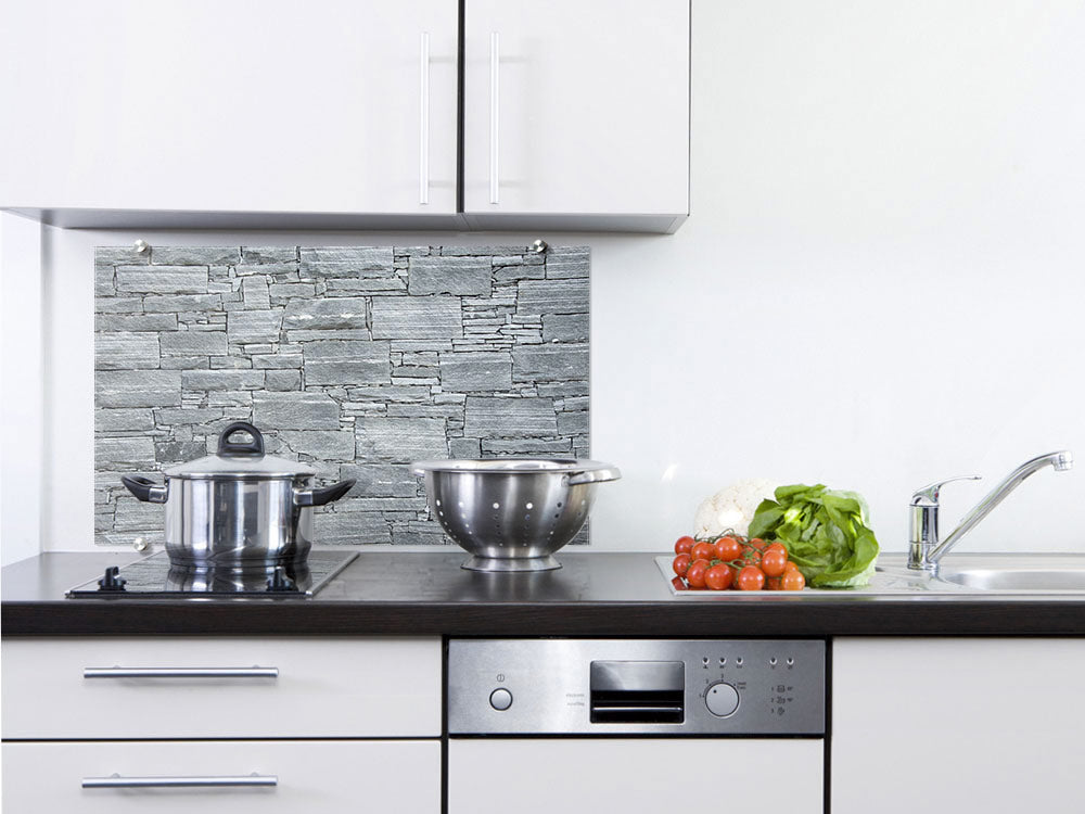 Küche mit grauem Steinmuster, Topf, Schüssel und frischem Gemüse.