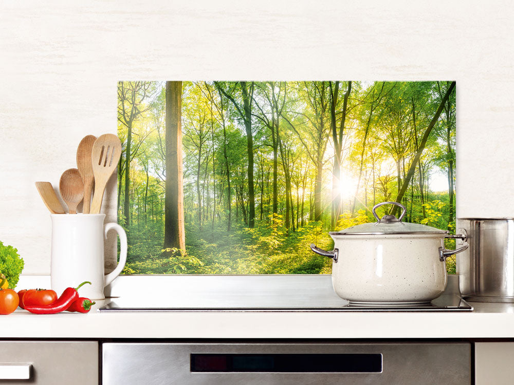 Küchenwand mit grüner Waldlandschaft und Sonnenlicht.