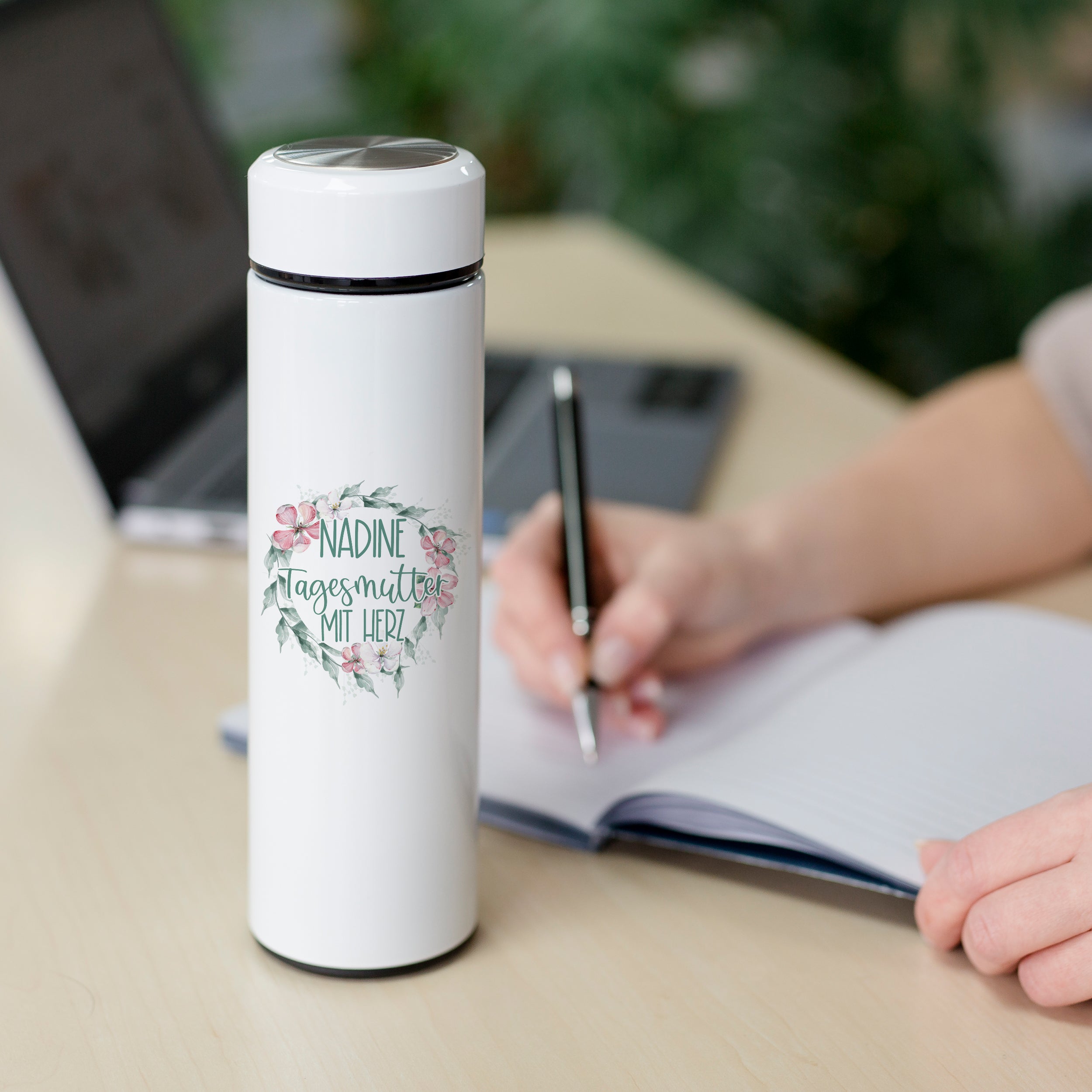 Weiße Thermosflasche mit floralem Design und persönlichem Namen.
