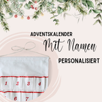 Personalisierter Adventskalender in Weiß mit roten Zahlen.