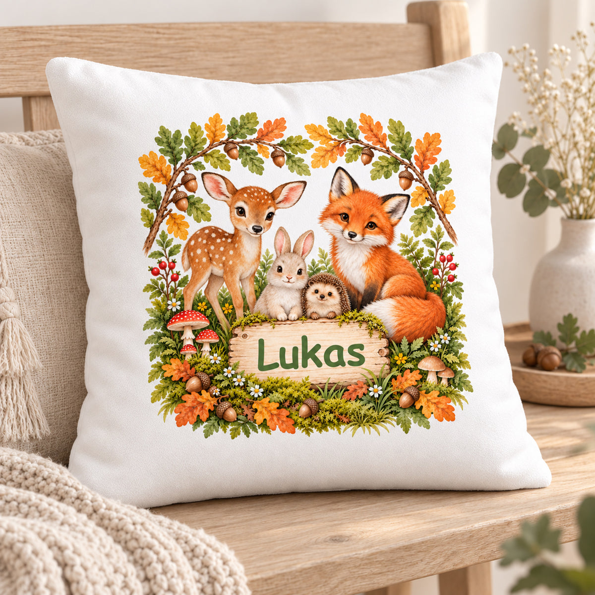 Dreiviertelansicht des Waldtier-Kissens „Herbstfreunde unter Eichenlaub“ mit Namensbeispiel Lukas auf einer Holzbank.