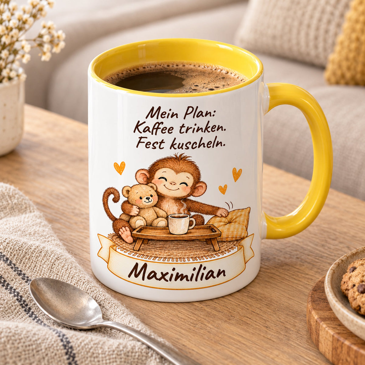 Schrägansicht: gelbe personalisierte Tasse mit Baby-Affe, Motiv Kaffee und Kuscheln, Beispielname Maximilian