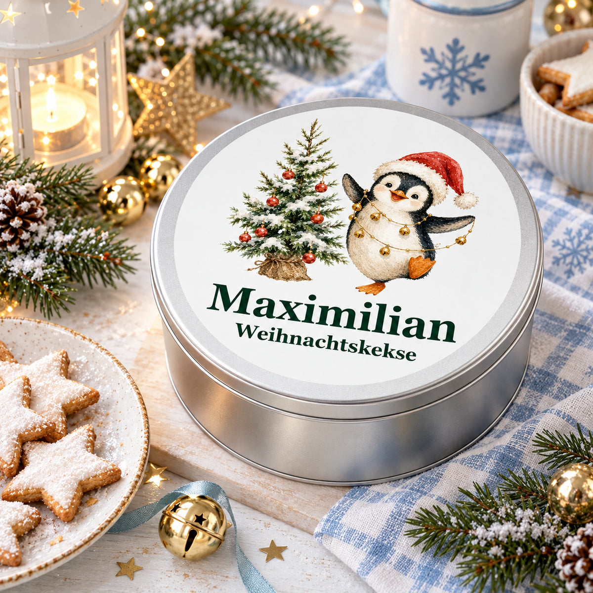 Runde Keksdose als weihnachtliche Geschenkidee mit Pinguin mit Glöckchenkette und Wunschname.