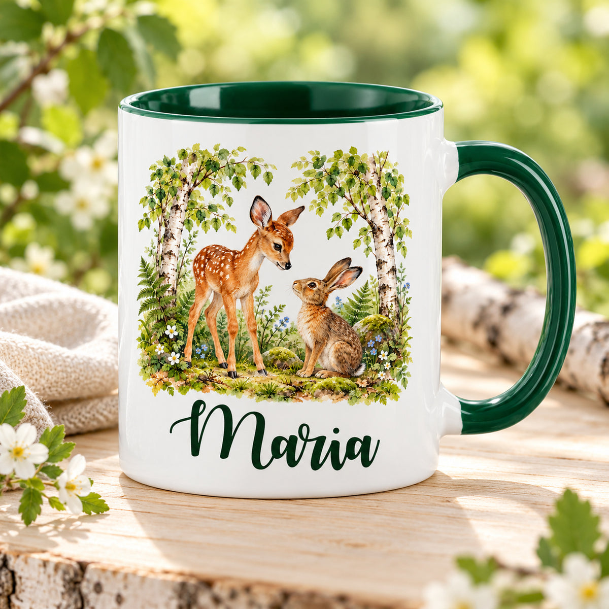 Weiße Namenstasse mit grünem Henkel und Waldmotiv: Rehkitz und Hase, auf einem Holztisch.