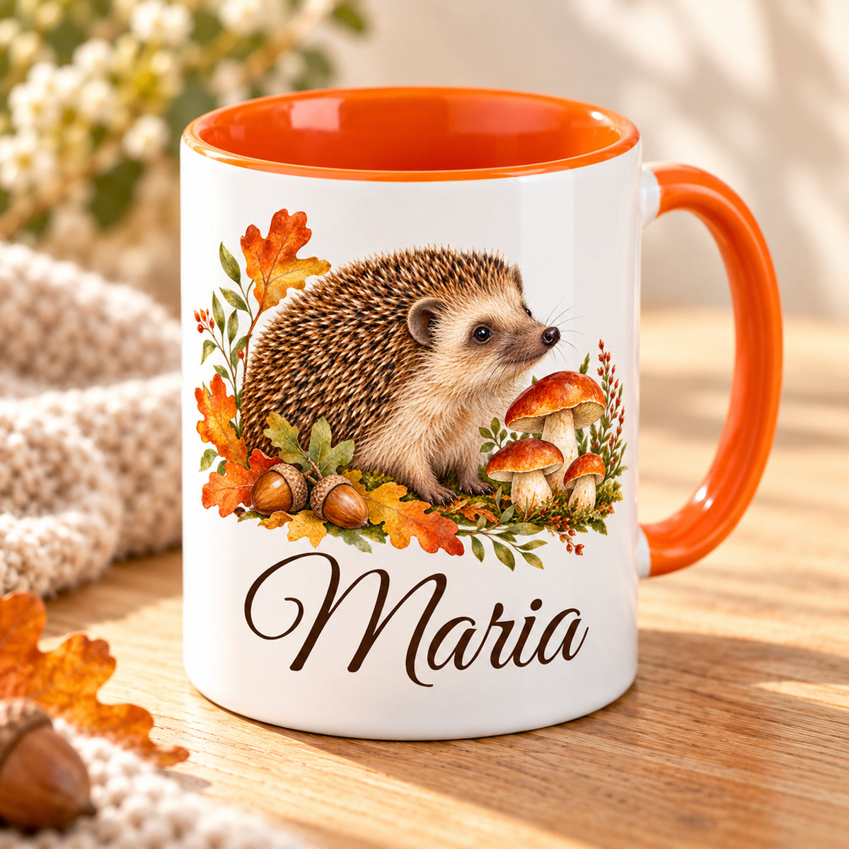 Tasse mit Igel, Pilzen und Herbstlaub und Namensdruck in schräger Ansicht mit orangefarbenem Innenbereich.
