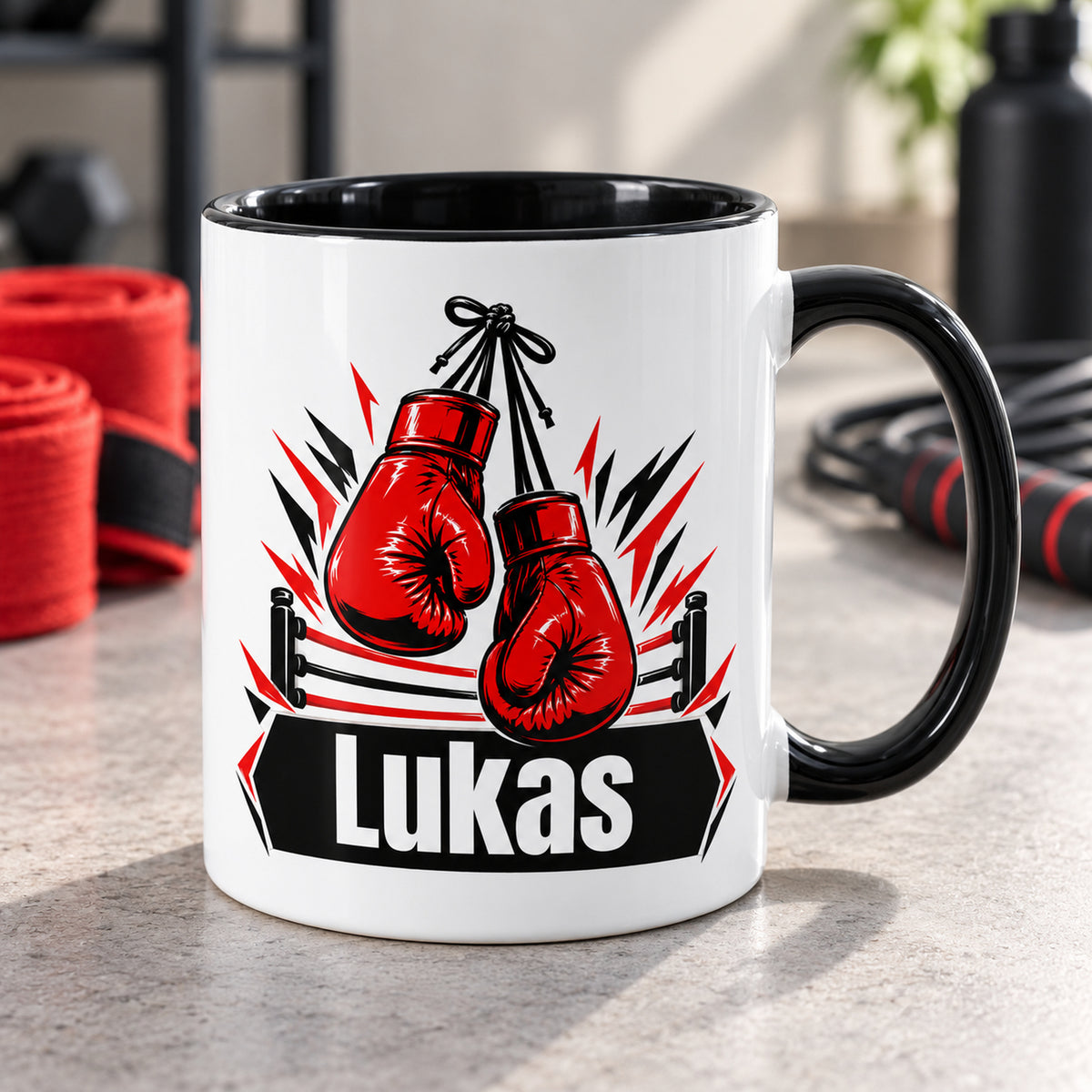 Weiße Boxsport-Tasse mit schwarzem Henkel und roten hängenden Boxhandschuhen, personalisiert mit Wunschnamen.