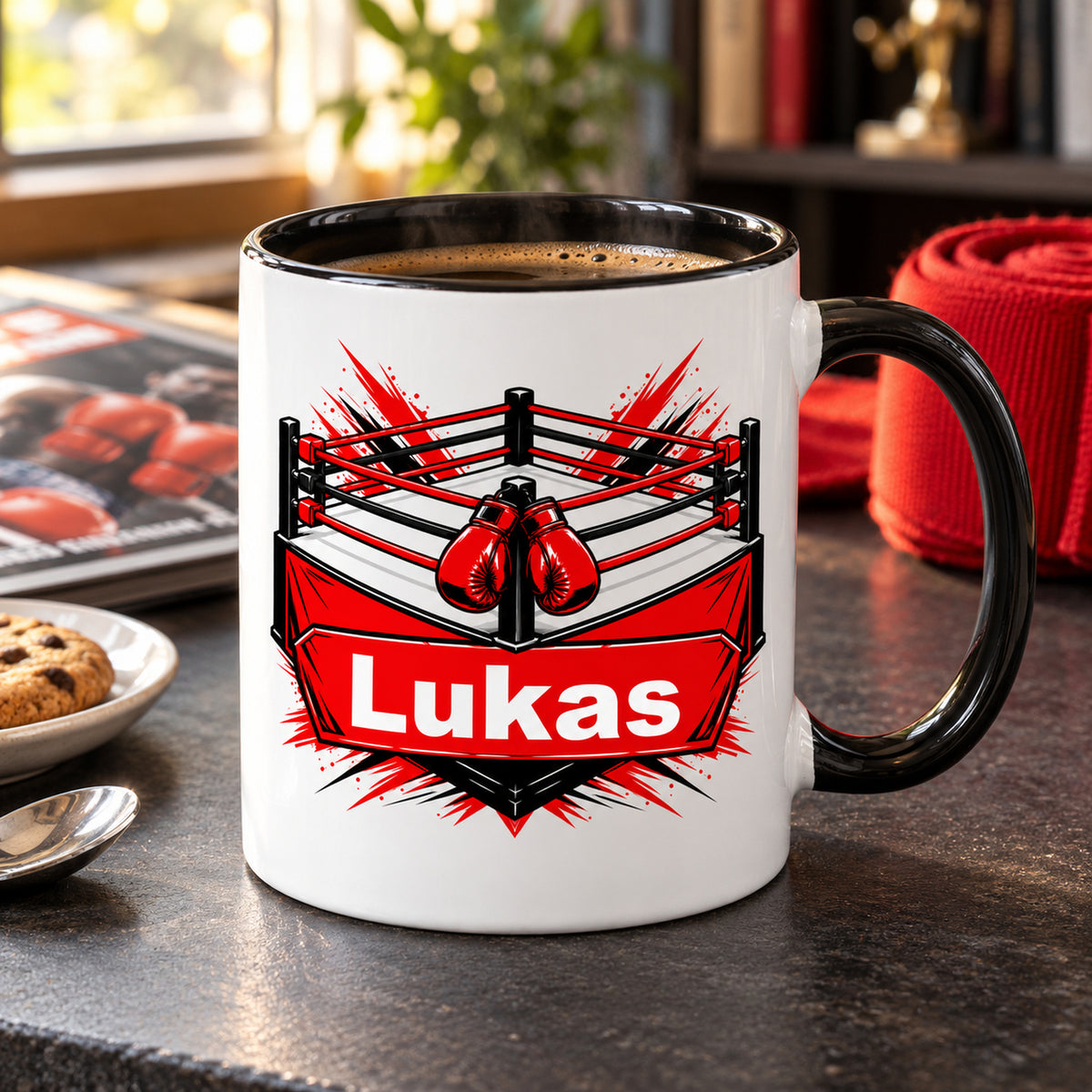 Boxring-Tasse mit Wunschname und Kaffee auf einem Tisch neben Handbandagen und Gebäck.