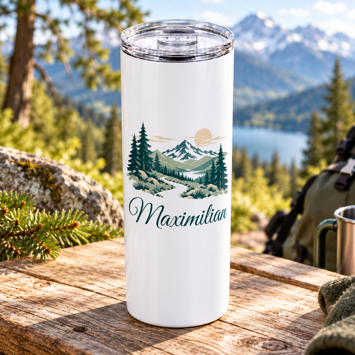 Thermobecher mit Waldpfad und Bergen und Wunschname, seitlich auf einem Tisch dargestellt.