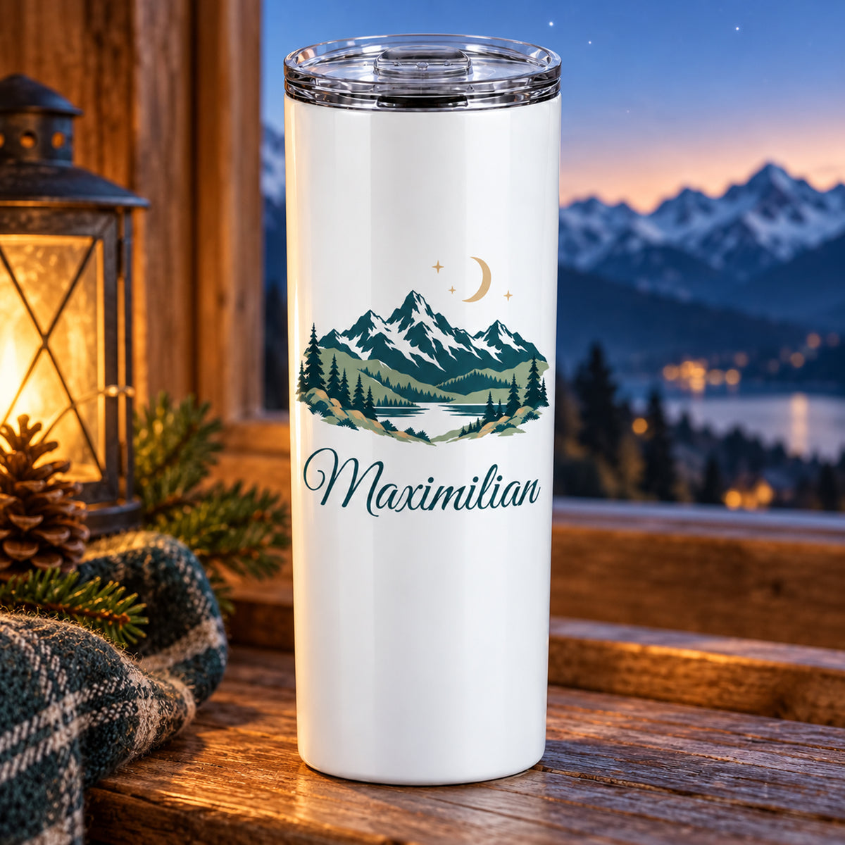 Thermobecher mit Bergen, Mond und Sternen und Wunschname neben einer Laterne in der Abenddämmerung.