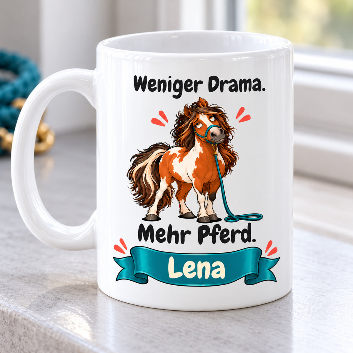 Weiße Pferdetasse mit Namen, Schecken mit petrolfarbenem Strick und Spruch „Weniger Drama. Mehr Pferd.“, mit Henkel links und identischem Motiv.