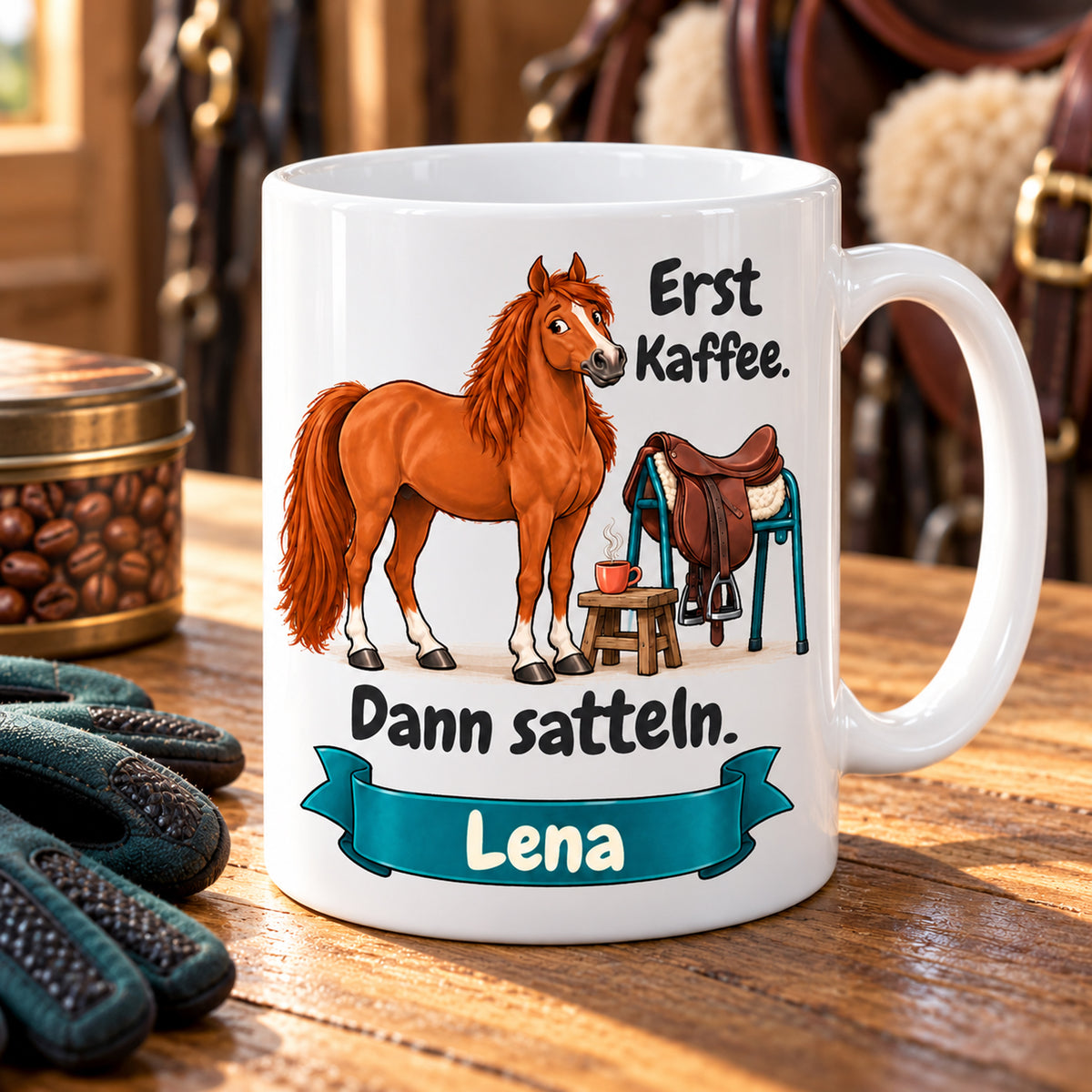 Weiße Pferdetasse mit Namen, Fuchs neben Sattel und Kaffeetasse und Spruch „Erst Kaffee. Dann satteln.“, schräg von vorn.