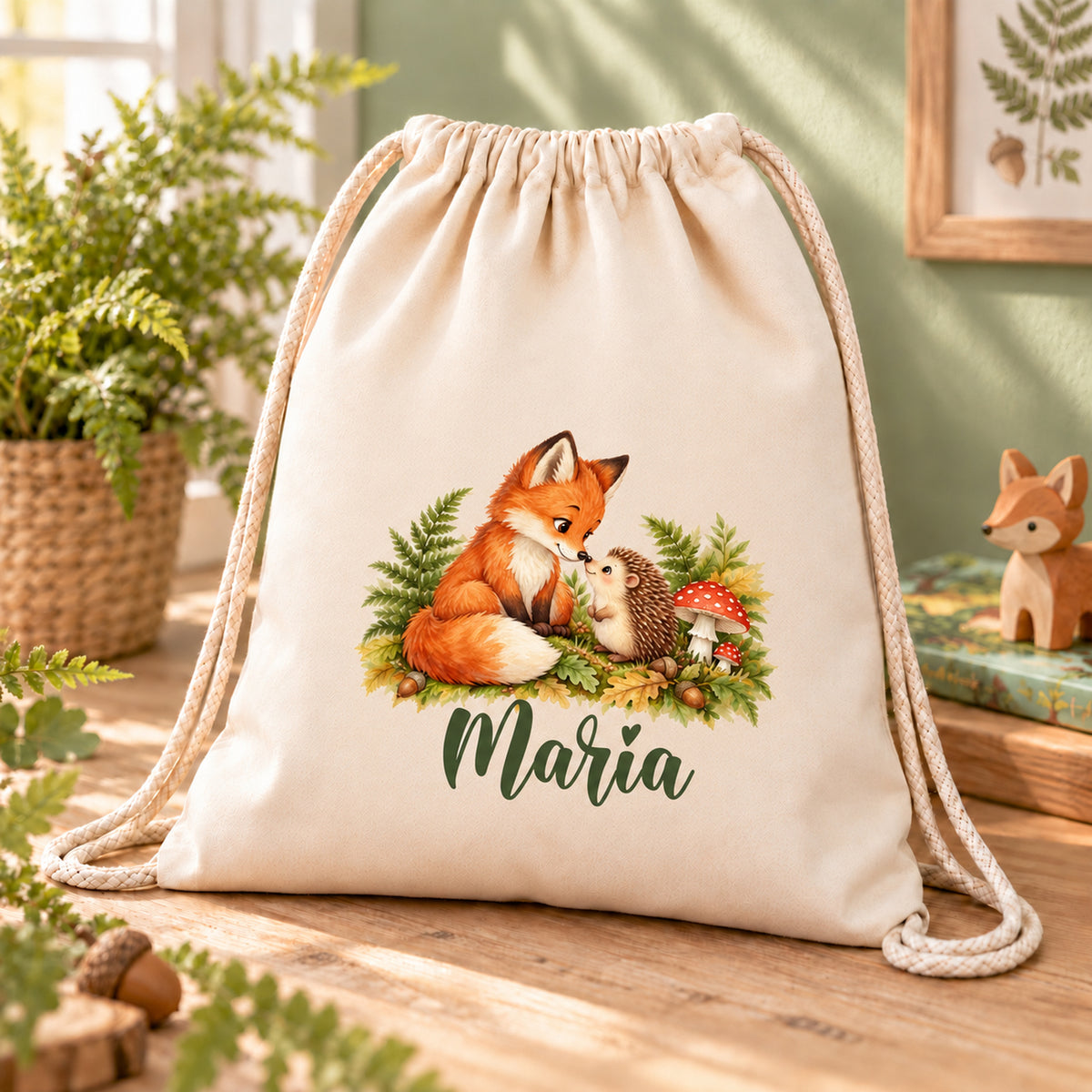 Turnbeutel mit Fuchs, Igel und Wunschname auf einem Holztisch mit Farn und kleiner Holzfigur